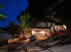 A modern house with a car parked in the driveway, a staircase leading to the entrance, and a tree in the foreground. - KAYAK-SUP-SWIM--ALL YEAR, Gorgeous  LAKE walks-Just STEPS away & Restaurants (Austin)