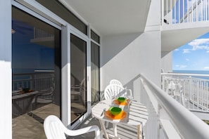 Enjoy ocean views from this balcony with a table and chairs, perfect for dining or relaxing.