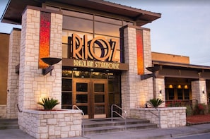 Experience the vibrant atmosphere of this Brazilian Steakhouse, marked by a striking entrance and inviting steps.