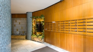Eine Lobby mit einer Holzwand, einem Kachelboden und einer Pflanzenausstellung.