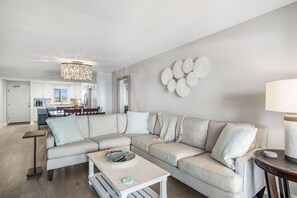 Een moderne woonkamer met een modulaire bank, een salontafel en een kroonluchter.