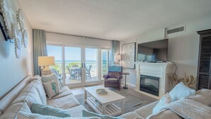 Una sala de estar moderna con sofá, sillón y chimenea.