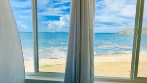 A room with a large window overlooking a beach. - The Waves; Oceanfront 2 Bedroom. Gorgeous Sunrises. Relax With The Wave Rythyms (Philipsburg)