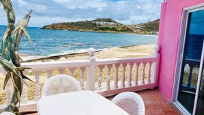 A balcony with a view of the sea and a hill with buildings. - The Waves; Oceanfront 2 Bedroom. Gorgeous Sunrises. Relax With The Wave Rythyms (Philipsburg)