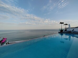 En pool med udsigt over havet og en klar himmel.