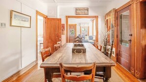 A dining room with a wooden table, chairs, a chandelier, and a sign that says 'Begin each day with a grateful heart.' - Family Fun & Sun in Bolton - walking distance to town, beaches, & lake (Bolton)