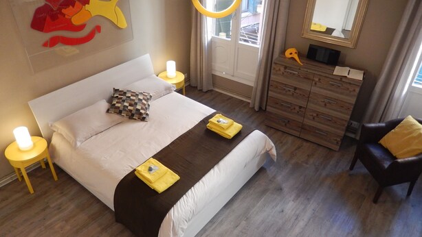 A bedroom with a bed, bedside tables, a dresser, a chair, and a mirror.