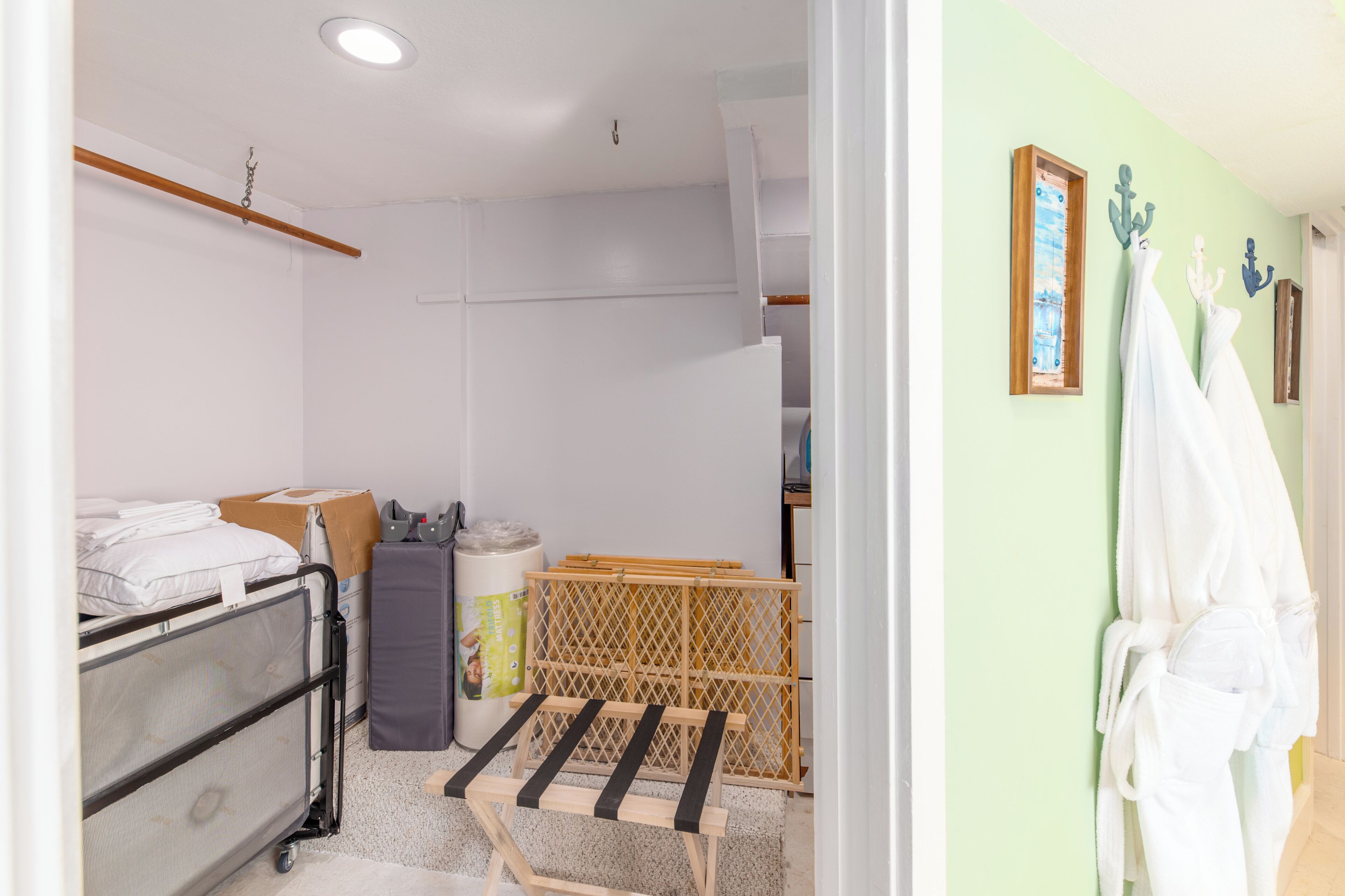 Een hotelkamer met een bed, een kleine tafel, een koffer en een badkamer zichtbaar door een open deur.