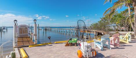 Un muelle con pasarela de madera, equipo de pesca y sillas.