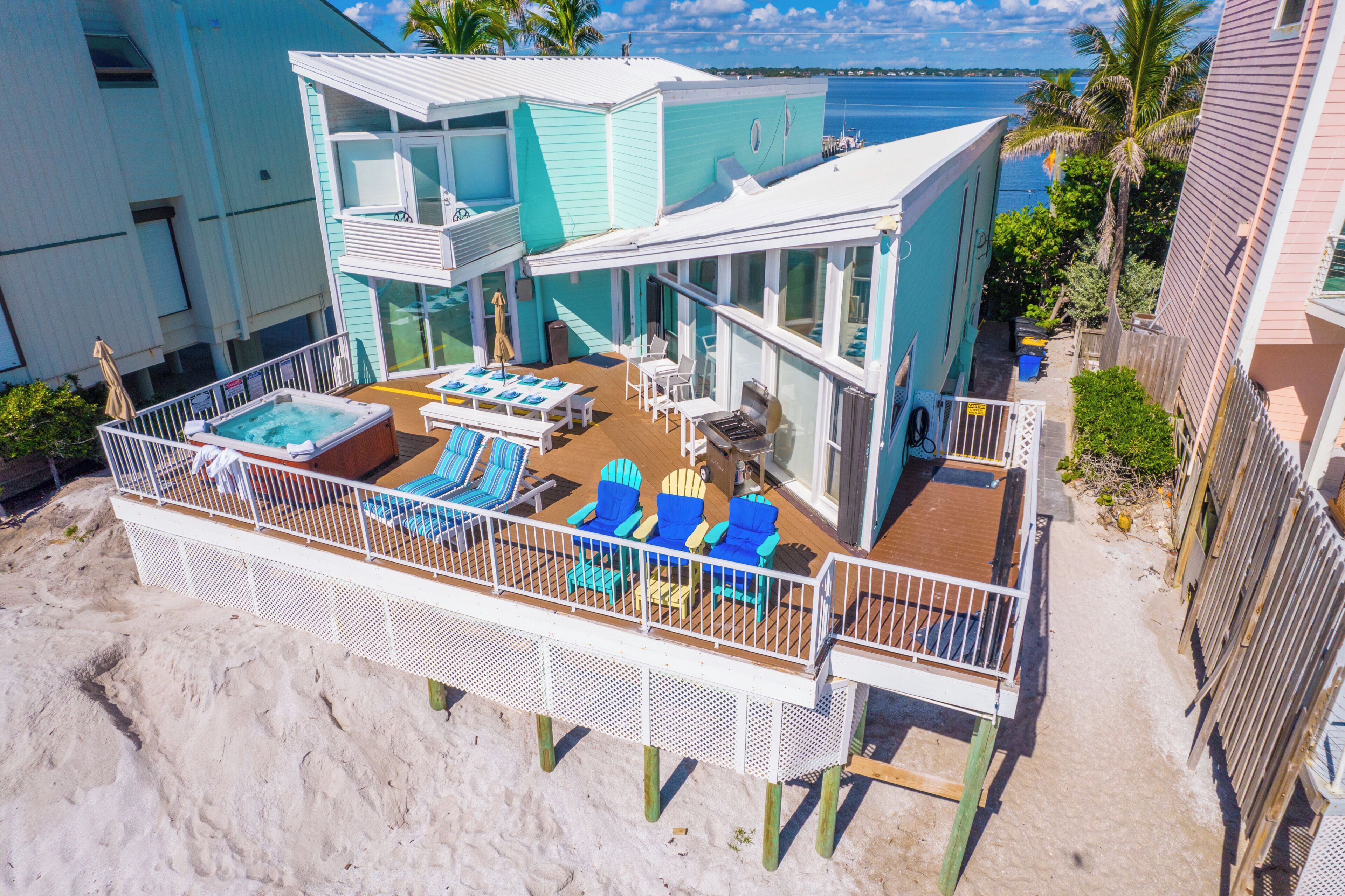 A beachfront property with a pool area, outdoor seating, and a view of the ocean.