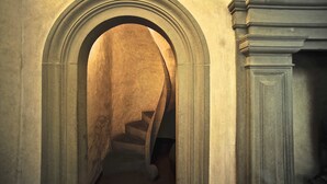 A stone staircase with an arched entrance leading to a lower level. - Luxury Renaissance Palace (Firenze)