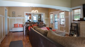 A spacious living area with a sofa, a dining table, and a kitchen in the background.