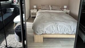 Une chambre moderne avec un grand lit, des tables de chevet, une commode et un canapé.