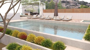 A rectangular swimming pool with lounge chairs and a wooden deck. - Beach Villa in Crete - Villa Kirvas (Ierapetra)