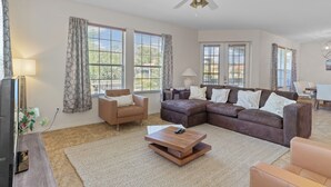 A spacious living room with a sectional sofa, a coffee table, and a TV. - Waterfront! Boat dock available for rent, pet friendly, families welcome!  (Homosassa)