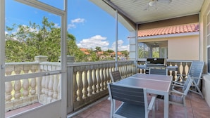 A covered outdoor patio with a table and chairs, a grill, and a view of the surrounding area. - Waterfront! Boat dock available for rent, pet friendly, families welcome!  (Homosassa)