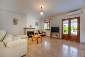 TV connectée, cheminée, livres, chaîne hi-fi