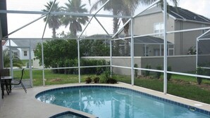 A swimming pool with a hot tub, surrounded by a covered area with a view of a house and palm trees. - Disney Quiet, Spacious, Contemporary / Salt Water Pool & Spa, Wi-fi (Davenport)