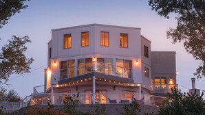 A multi-story building with balconies, large windows, and string lights. - Skyline Views, Hot Tub, Beachfront, Lavish Kitchen at Dunetop Villa (Miller Beach)