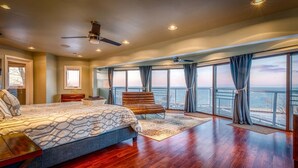 A spacious bedroom with a large bed, a seating area, and a view of the ocean. - Skyline Views, Hot Tub, Beachfront, Lavish Kitchen at Dunetop Villa (Miller Beach)