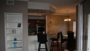 Een moderne keuken met een centraal eiland, barstoelen en hanglampen.