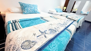 Een hotelkamer met een groot bed, twee nachtkastjes en een bijzettafeltje.