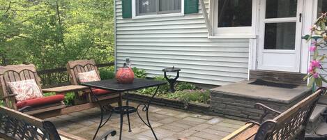 A patio with outdoor furniture, a table, and a decorative vase.
