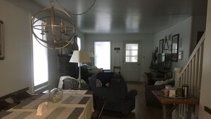 Un comedor con una mesa preparada para dos personas, un candelabro y vistas de la cocina y el salón.