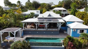 A residential property with a swimming pool, covered patio, and multiple houses with satellite dishes. - Zen Villa in residential area (Saint francois)