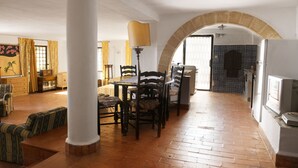 A spacious living area with a wooden floor, a dining table with chairs, a large white column, and an arched doorway leading to another room. - Relax with pool and see view! (Altavilla Milicia)