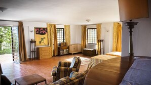 A spacious living room with a sofa, armchair, and a wooden coffee table. There is a painting on the wall, a lamp, and a window with curtains. - Relax with pool and see view! (Altavilla Milicia)