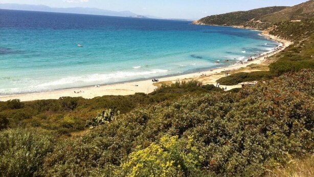 A coastal landscape with a beach, clear blue waters, and a hilly backdrop. - Villa Kala Nostra by the sea, 150m and 5m walk from Kal'eMoru/Villasimius shoreline (Geremeas)