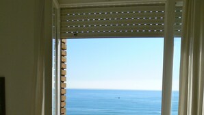 Vue depuis un balcon, avec l’océan et la plage qui s’étendent à l’arrière-plan.