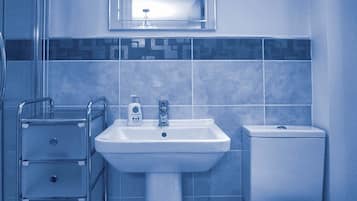 Een bad/douchecombinatie, een haardroger, handdoeken, zeep