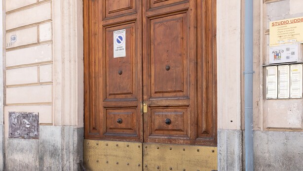 A large wooden double door with a metal decorative arch above it, a sign indicating no parking, and a building number 231. - Vittorio | Design and comfort in the center of Rome (Roma)