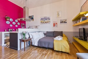 A modern bedroom with a bed, bedside table, and a TV stand.