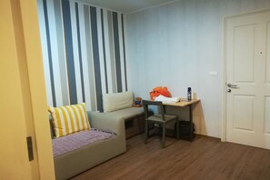 A small, cozy room with a sofa, a chair, a desk, and a teddy bear. - 1BR in U Delight at Huamak Station (Bangkok)