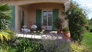 A covered patio with outdoor furniture, a potted plant, and a garden with lavender and other greenery. - House / Villa - Uzès (Uzès)