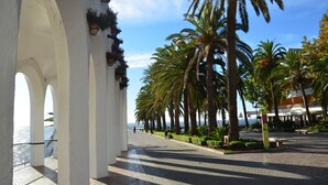 A coastal promenade with white arches, palm trees, and a view of the sea. - GREAT HOUSE IN PARADOR AREA WITH POOL AND SEA VIEWS CLOSE TO BURRIANA AND CITY (Nerja)