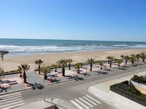 A beach with a parking lot and palm trees. - House with pool, barbacue and garden, to 1500 meters from the fine sandy beach (Cubelles)