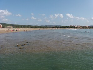 A beach with clear water, people, and buildings in the background. - House with pool, barbacue and garden, to 1500 meters from the fine sandy beach (Cubelles)