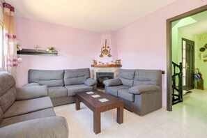 A living room with two grey sofas, a wooden coffee table, and a fireplace with decorative items.