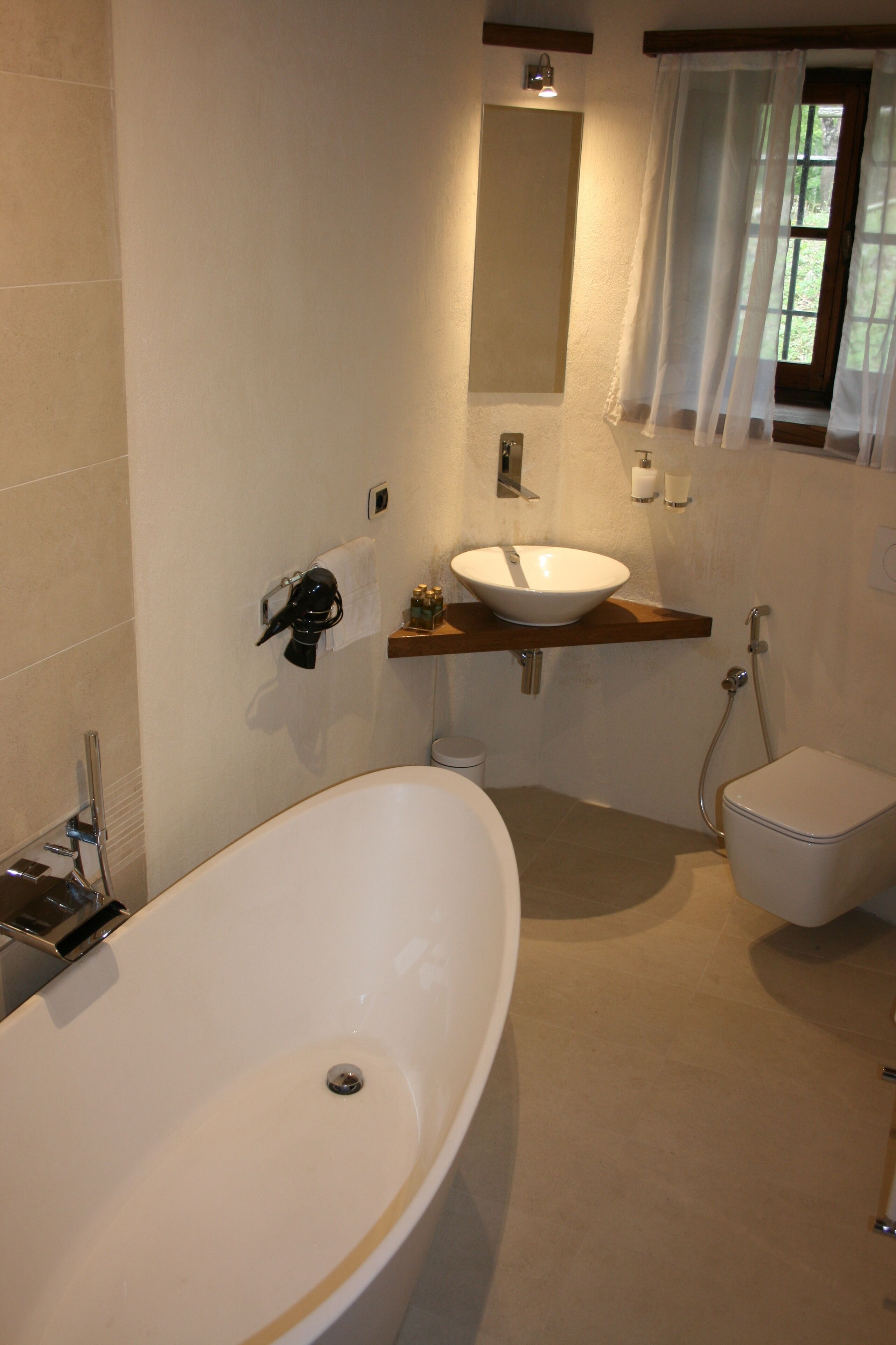 A bathroom with a freestanding bathtub, a pedestal sink, and a toilet.
