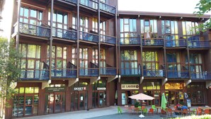 A multi-story building with balconies, a ski rental sign, and a restaurant named "LE FLAVOIR".