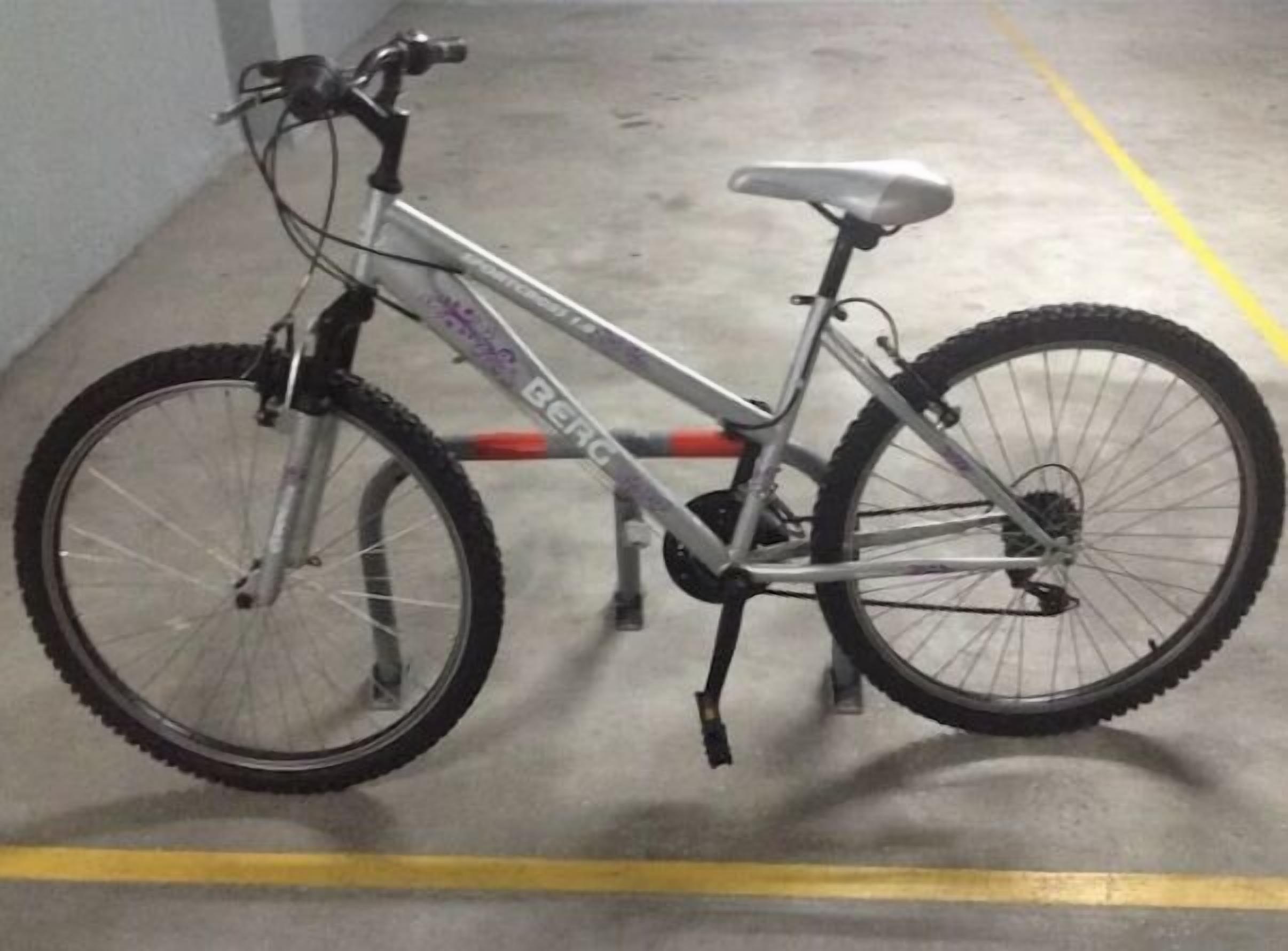 Een fiets geparkeerd in een parkeerplaats.