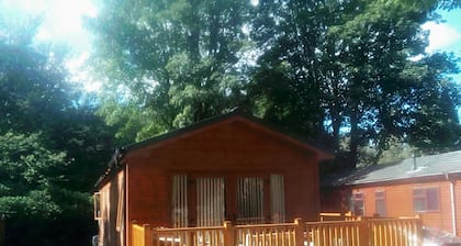 Cabaña de madera en las orillas del lago Windermere, rodeada de un paisaje impresionante