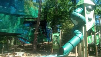 A playground with a slide and climbing structures.