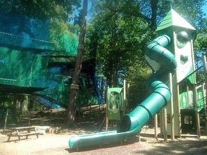 A playground with a slide and climbing structures.