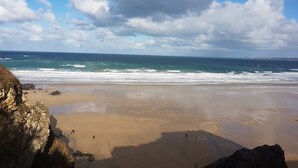 Una playa con acantilados rocosos y olas.