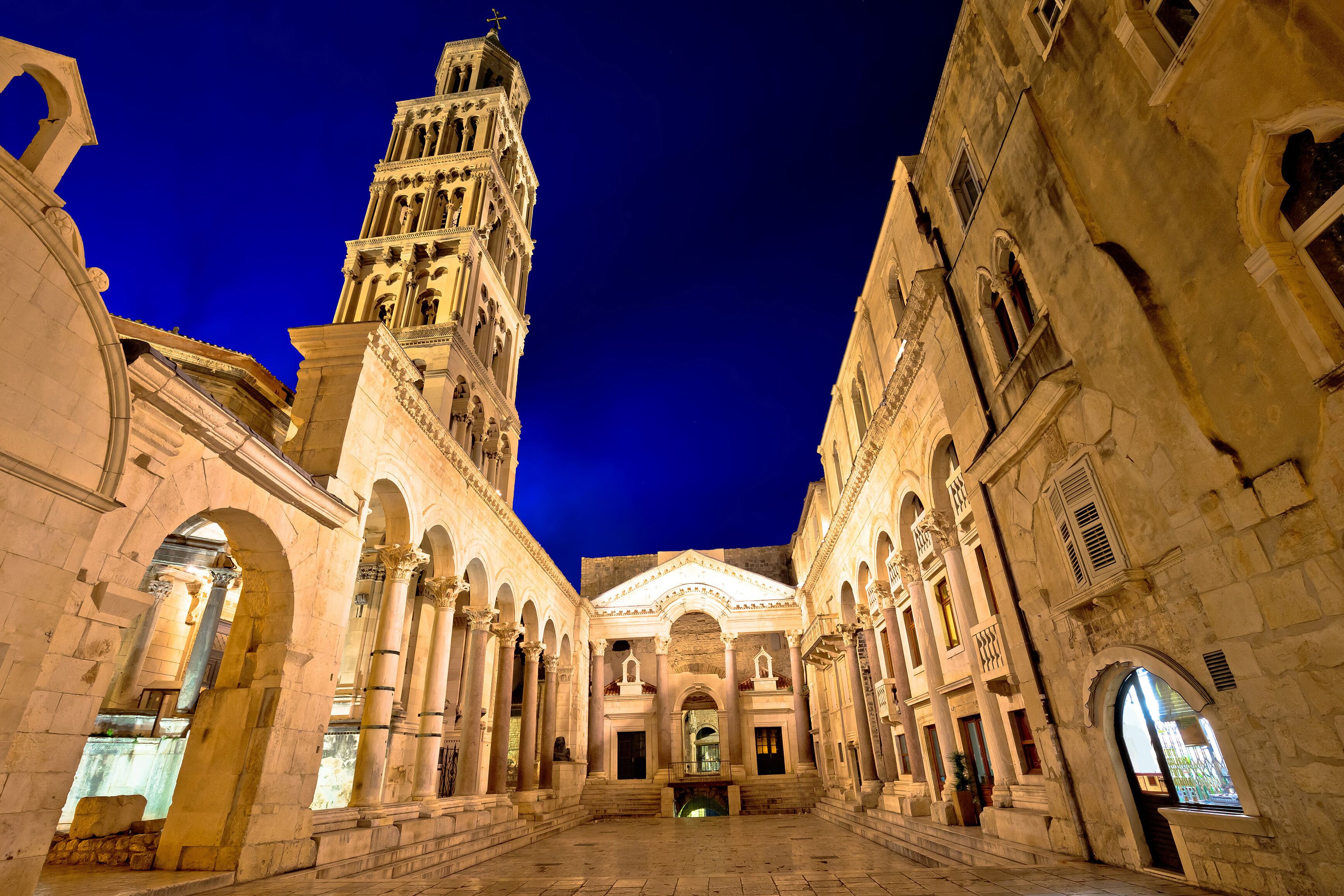 A historic building with a prominent bell tower and arched walkways.